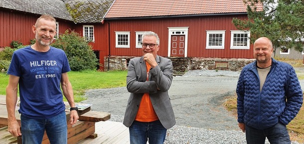 Ole Dybwad, Tommy Reinås og Eivind S Mjøen foran rød bygning i gårdstunet