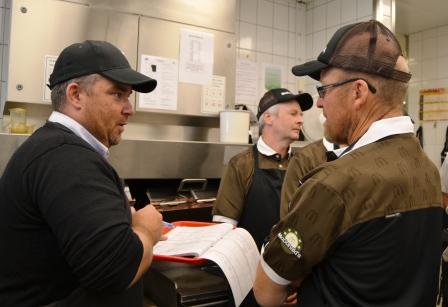 Stian Åsen i McDonald's viser fylkesleder Asbjørn Helland sjekklista for restauranten. Her er det strenge krav til både råvarer og hygiene.